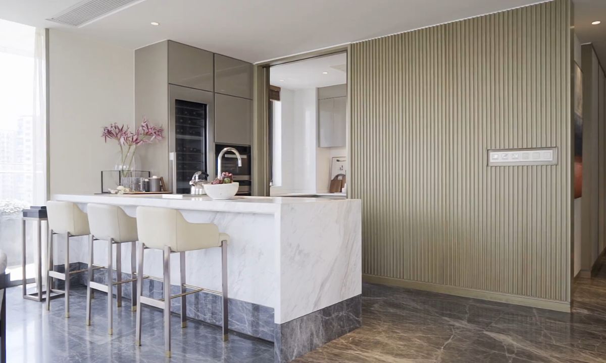 prikaz kuhinje sa belim šankom na sredini, drvenim pločama na zidu, elegantan dizajn